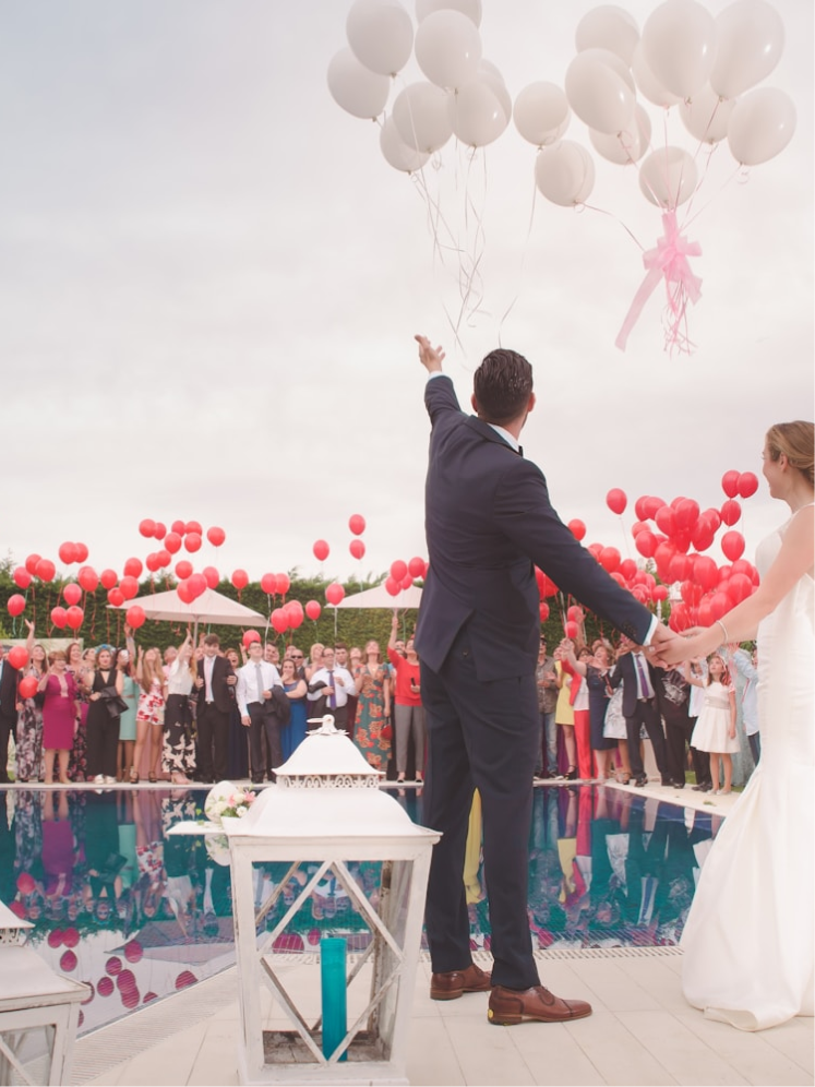 Guests releasing balloons beside the pool as the couple celebrate