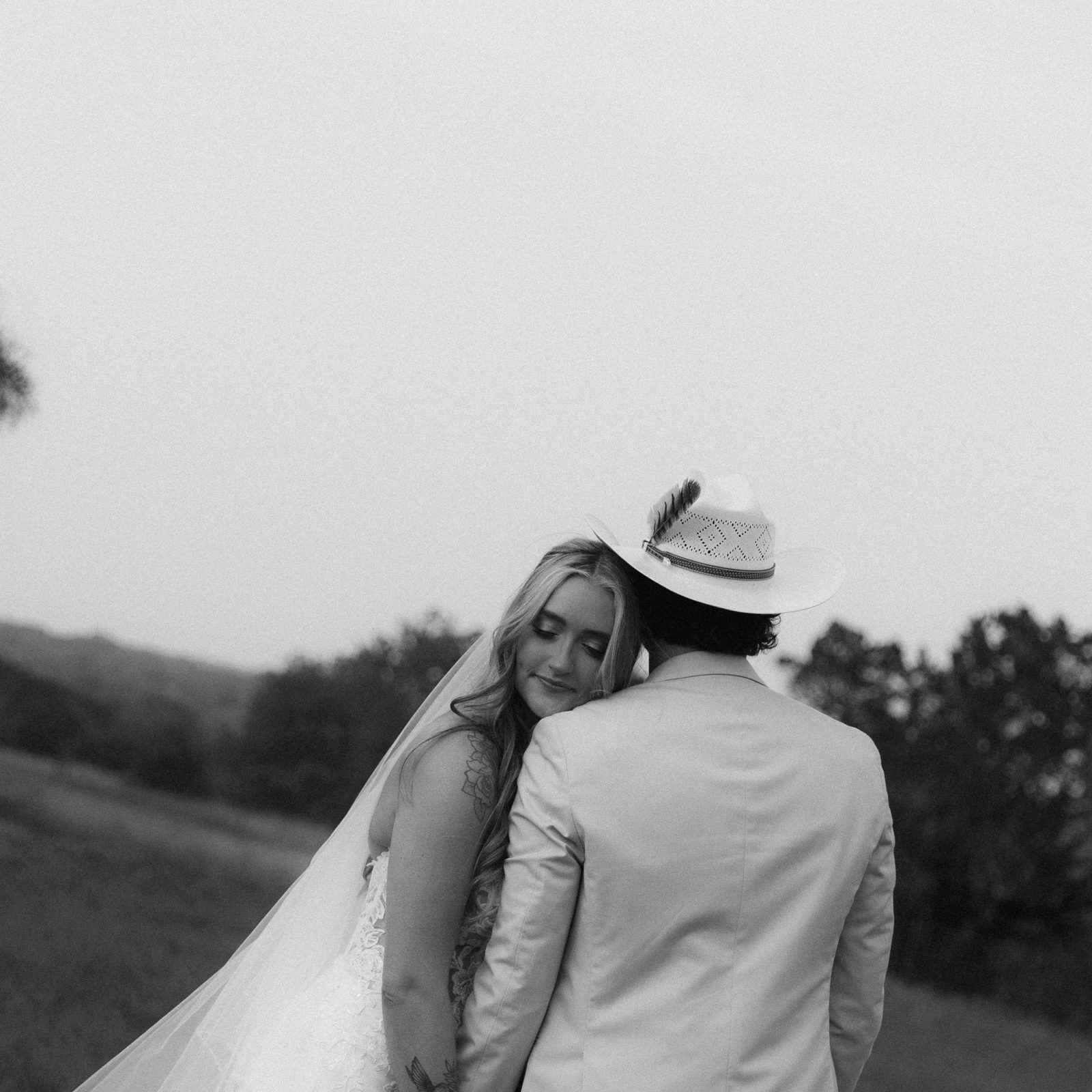 Black and white photograph of a bride and groom walking away hand in hand